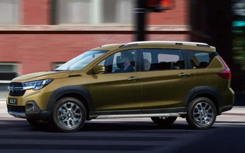 Suzuki XL7 de color dorado circulando por una ciudad.