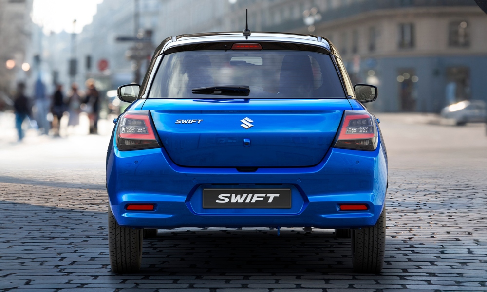 Vista trasera de auto hibrido Suzuki Swift color azul.