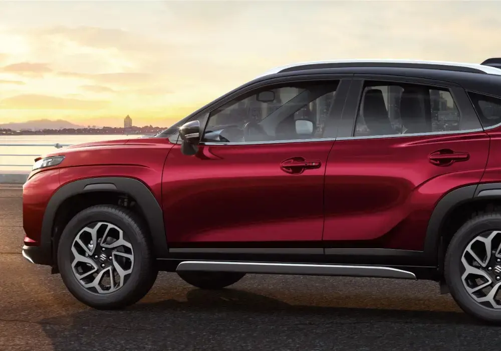 Suzuki Fronx rojo estacionado en una carretera con un horizonte urbano